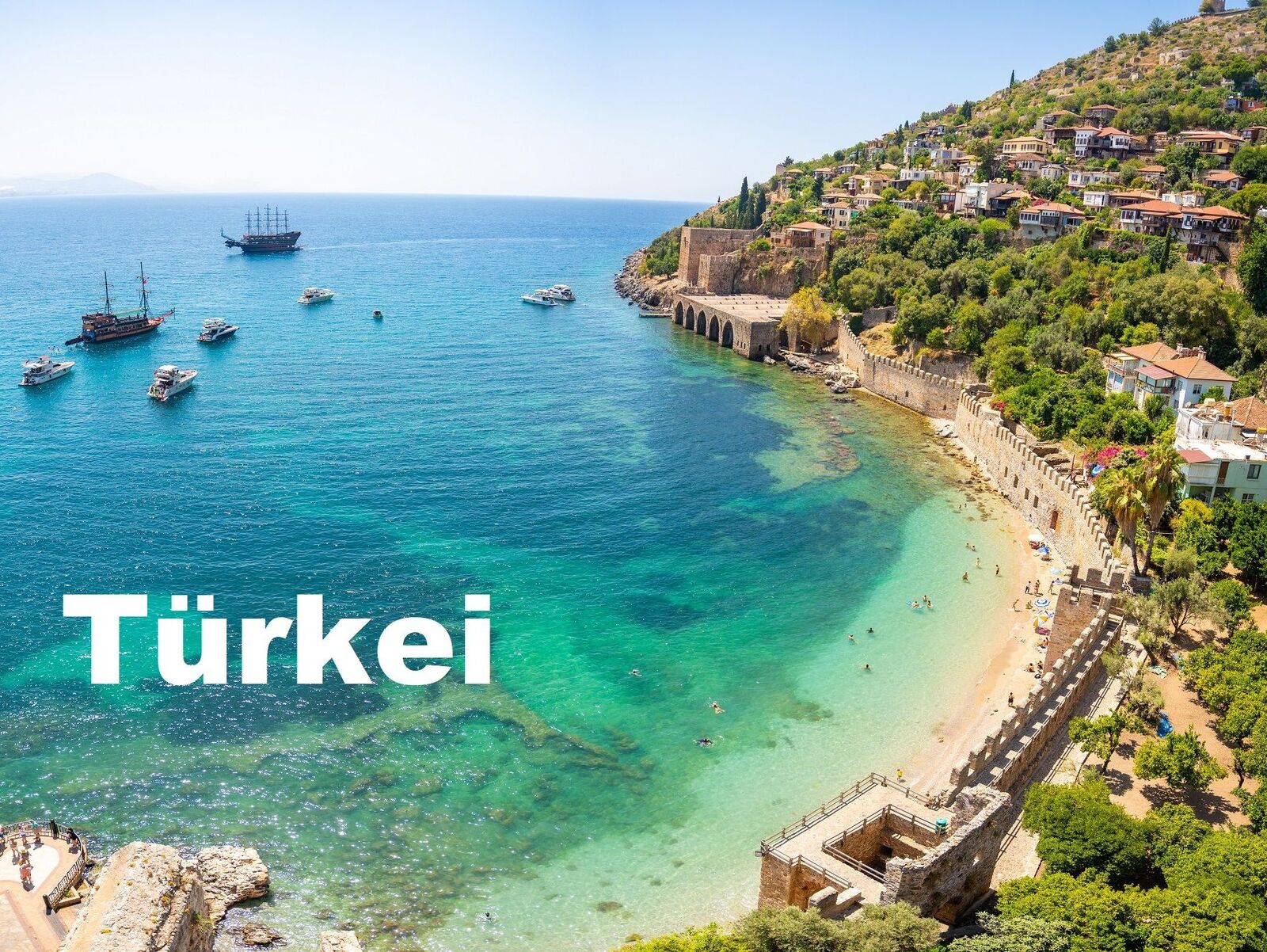 Ancient shipyard or Tersane near of Kizil Kule tower and beautiful beach and calm turquoise sea surface in Alanya, Turkey